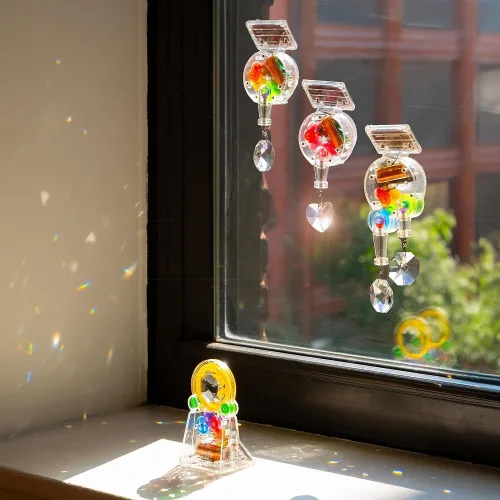 Vista 3 de Kikkerland Fabricante de arco iris con energía solar, atrapasoles de prisma, decoración divertida para ventanas del hogar, regalo único para Navidad